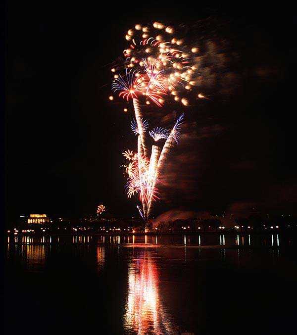 A medium close up view of fireworks lighting up the sky near the river entrance to the Jefferson Memorial, to begin the 1997 Inaugural Celebration.