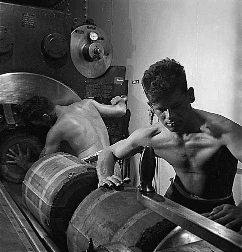 Barbette of 16-inch gun on board the USS New Jersey (BB-62) 11/1944. Gunners packing in bags of powder which will fire the huge shell already in gun.